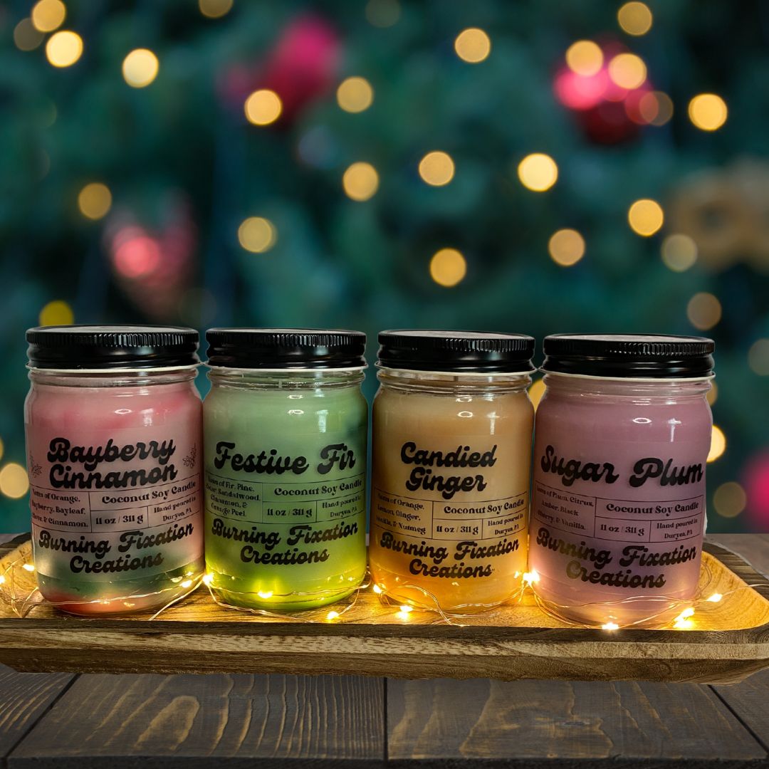 Holiday candle collection with 4 candles, a red and green swirled Bayberry Cinnamon candle, a green swirled Festive Fir candle, an Orange and brown swirled Candied Ginger candle, and a red and purple swirled Sugar Plum scented candle. 